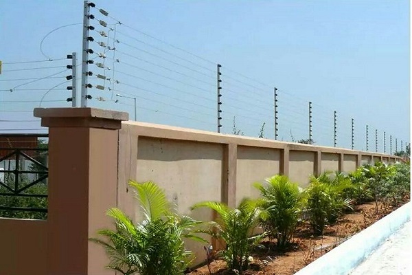 Solar-powered electric fencing along a perimeter wall